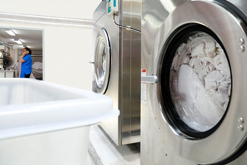 Gewerbliche Waschmaschinen in einer Klinikwäscherei bei der Wäscheaufbereitung